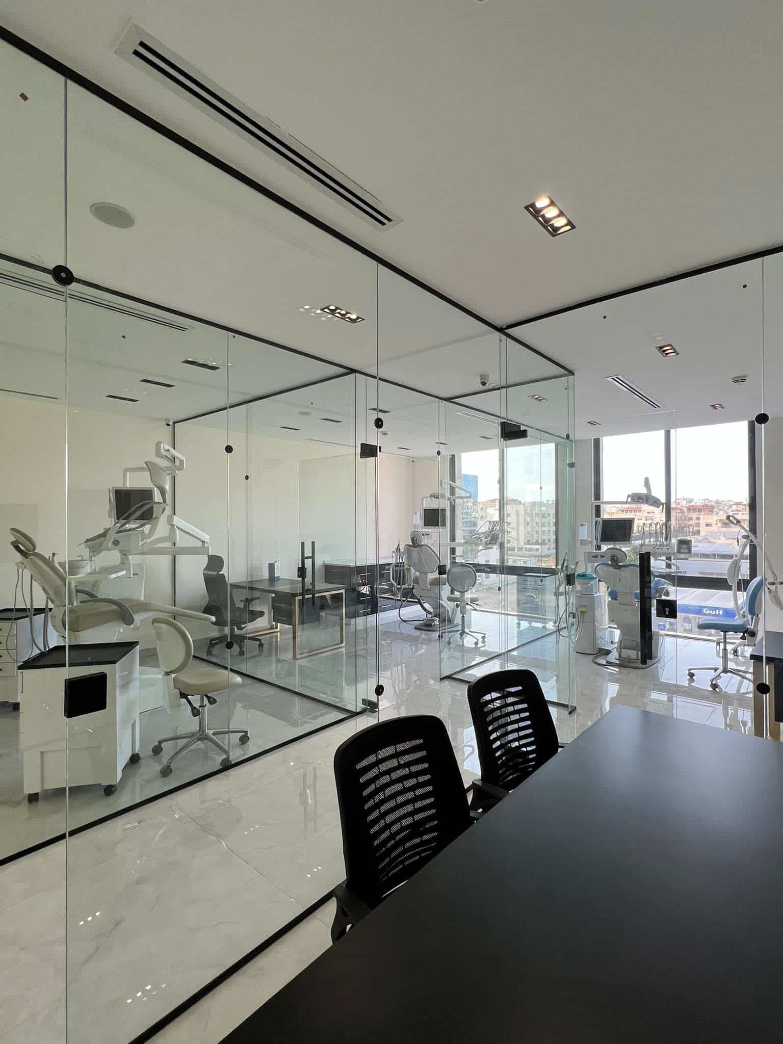Glass-walled dental treatment suites inside Innovative Dental Center in Amman, overlooking the city